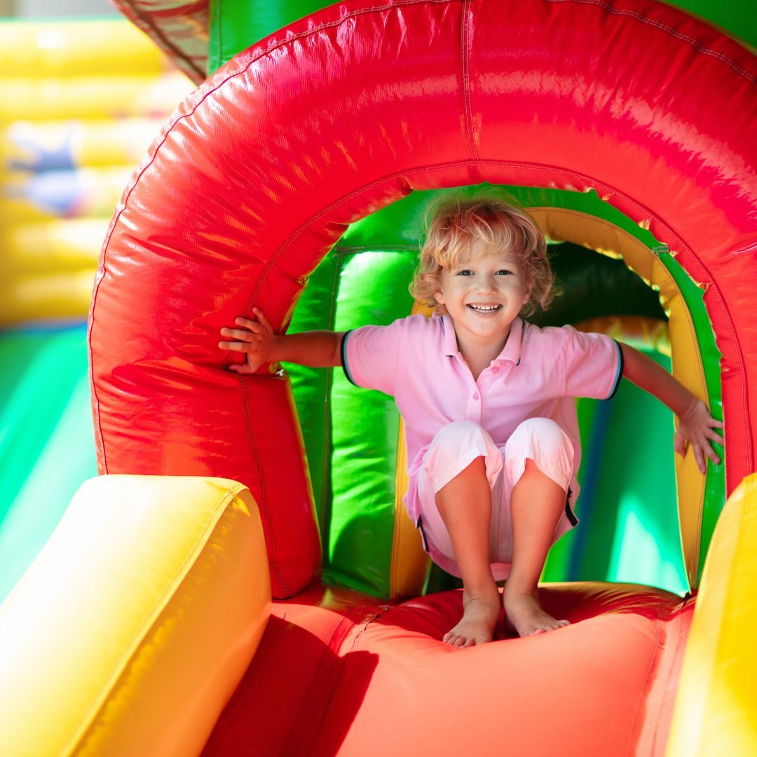 kid on inflatable slide